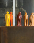 A group of people admiring a Gardeco Ceramic Sculpture Visitor Plus Yellow Acafrao Clear Cor36 in front of an art-filled window, showcasing exquisite interior design.