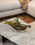 A Gardeco Candle 160 Fume Amber with yellow flowers on a marble table, accompanied by elegant candles.