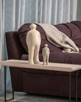 Two Gardeco Ceramic Sculpture Visitor Plus Beige Cor46 sculptures displayed on a table next to a couch.