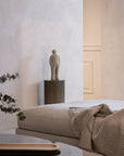A room with a Gardeco bed, a Gardeco table, and a Gardeco Ceramic Sculpture Visitor Plus Beige Cor46 vase.