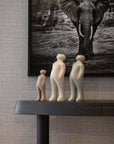 A Gardeco Ceramic Sculpture Visitor Plus Sand Cor02 of three figurines on a table next to a picture of an elephant.