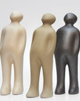 A Gardeco Ceramic Sculpture Visitor Plus Sand Cor02 standing next to other figurines on a white surface.