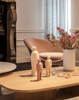 A meticulously crafted living room featuring a Gardeco Ceramic Sculpture Visitor Small Dune Cor47 coffee table adorned with a small figurine and a beautifully arranged vase of flowers, all showcased in an exquisite Dune finish.