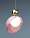 A versatile and vibrant lighting design from the Aurora Collection by Italamp featuring brushed gold accents, white glass diffuser, and retro-inspired finishes. A close of the pink and gold version on a eclectic blue color background