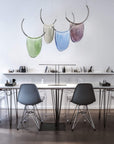 A room with an Italamp Dali table, Italamp Dali chairs, and Italamp pendant lights.