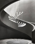 A modern building staircase featuring a stunning Italamp Pulsa Spira chandelier for illumination.
