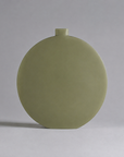 A minimalist, round ceramic vase with a small top neck and a matte sage green finish, photographed against a neutral light gray background.