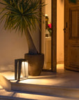 A Les Jardins LJ Solar Lantern SKAAL Tink121 Large 500L Duratek adds organic charm to an outdoor oasis, illuminating the steps of a house and accenting a potted plant.
