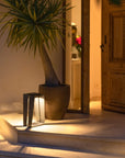 A Les Jardins LJ Solar Lantern SKAAL Tink121 Large 500L Duratek adds organic charm to an outdoor oasis, illuminating the steps of a house and accenting a potted plant.