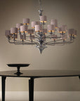 A Lorenzon Divina Chandelier, showcasing timeless elegance and Italian craftsmanship, illuminates a room adorned with a table and chairs.