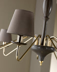 The Lorenzon Divina Chandelier showcases timeless elegance with its gold design and Italian craftsmanship, accentuated by a grey shade.