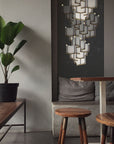 A room with two stools and a Meystyle Lattice Systems LED Wall Paper with Swarovski Chandelier illuminating the space with ambient lighting.