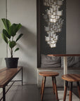 A room with two stools and a Meystyle Lattice Systems LED Wall Paper with Swarovski Chandelier illuminating the space with ambient lighting.