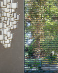 An architecture-inspired bench in front of a window, accentuated by the gentle glow of ambient lighting, complemented by the Meystyle Lattice Systems LED Wall Paper with Swarovski chandelier.