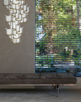 An architecture-inspired bench in front of a window, accentuated by the gentle glow of ambient lighting, complemented by the Meystyle Lattice Systems LED Wall Paper with Swarovski chandelier.
