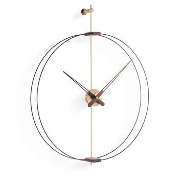 A Clock Nomon Barcelona Mini Gold MBARG by Nomon with a circular shape hanging on a wall.