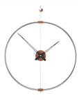 A Nomon Barcelona Mini MBAR wall clock with a circular shape hanging on a wall, featuring an elegant and sophisticated design.