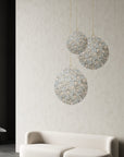 A living room with a Germanium LED Wall Paper with Swarovski couch by Meystyle, and three hanging balls providing ambient lighting.