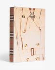 Linen slip case. Burberry coffee table book by Assouline, celebrating 165 years of British style, iconic trench coats, and timeless luxury through stunning illustrations and stories.