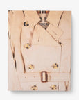 Front slip cover in linen. Burberry coffee table book by Assouline, celebrating 165 years of British style, iconic trench coats, and timeless luxury through stunning illustrations and stories.