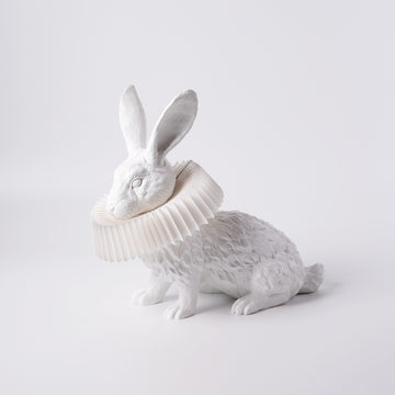 A Haoshi Rabbit Squat Table Lamp with a crown on its head, emitting warm LED light.