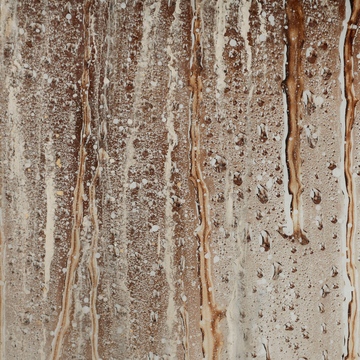 A close up of a decorative brown wall with Alex Turco Underwater Drops in Bronze dripping from it.
