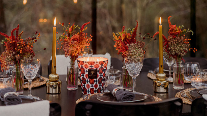 Luxury aromatic candle from Baobab Collection styled on an elegant dining table with floral arrangements, creating a warm and inviting atmosphere for interiors, available at Spacio Collections India.