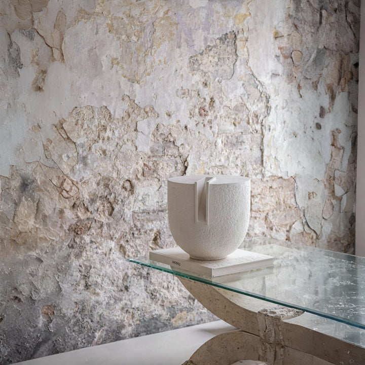 Clausa Forma ceramic sculpture by Guy Buseyne for Gardeco, displayed on a glass table against a rustic textured wall. Available at Spacio India, this minimalist art object adds quiet elegance to contemporary and wabi-sabi interiors.