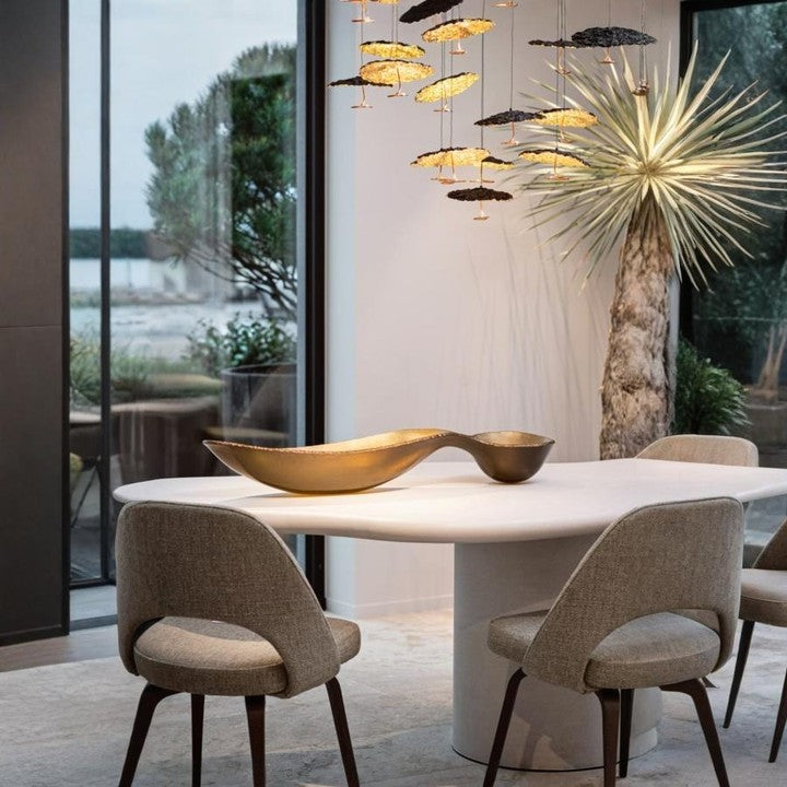 Modern dining room with designer pendant lighting and sculptural gold centrepiece from Spacio’s luxury collection