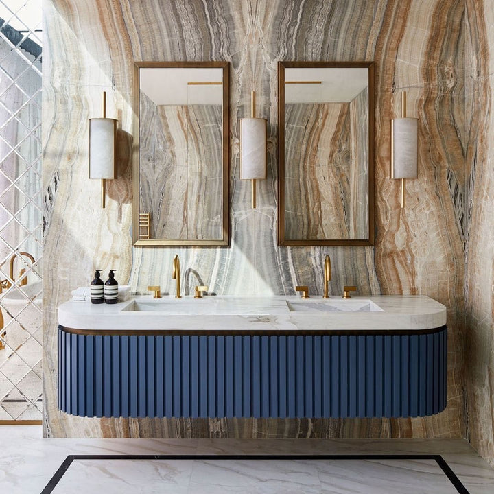 Double vanity bathroom with fluted blue cabinetry, onyx wall, and brass fittings – a modern luxury styling highlight for 2025