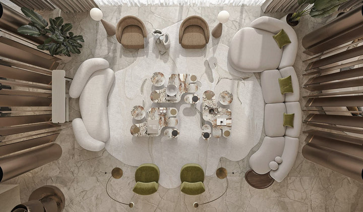 Top view of a modern private lounge featuring curved designer sofas, sculptural armchairs, and marble coffee tables on a layered carpet.