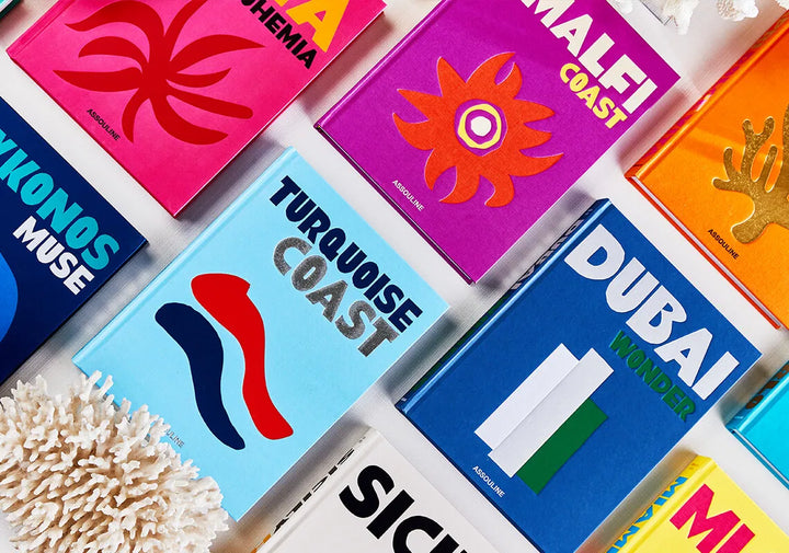 Collage of Assouline travel series coffee table books in bright colour at Spacio