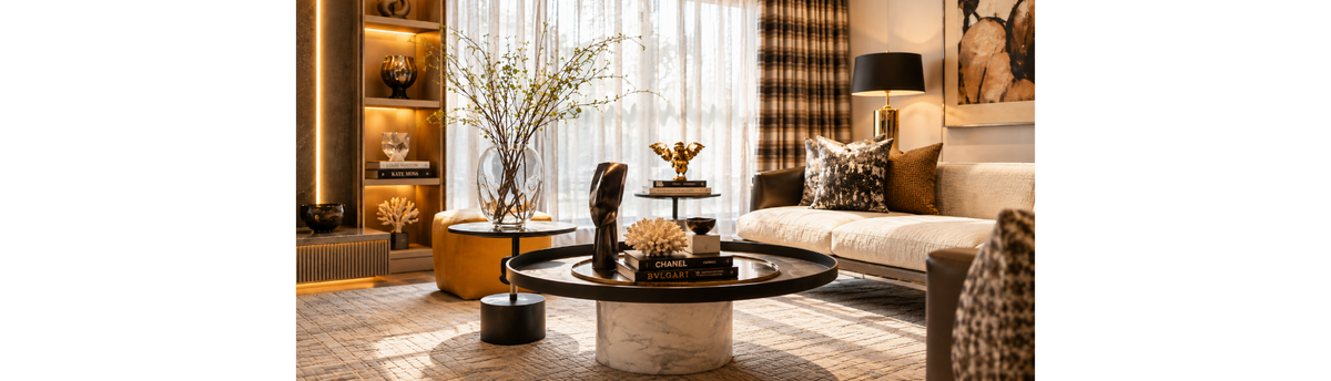 Luxury living room styled with vases, sculptures, coffee table books and decorative objects using balanced negative space