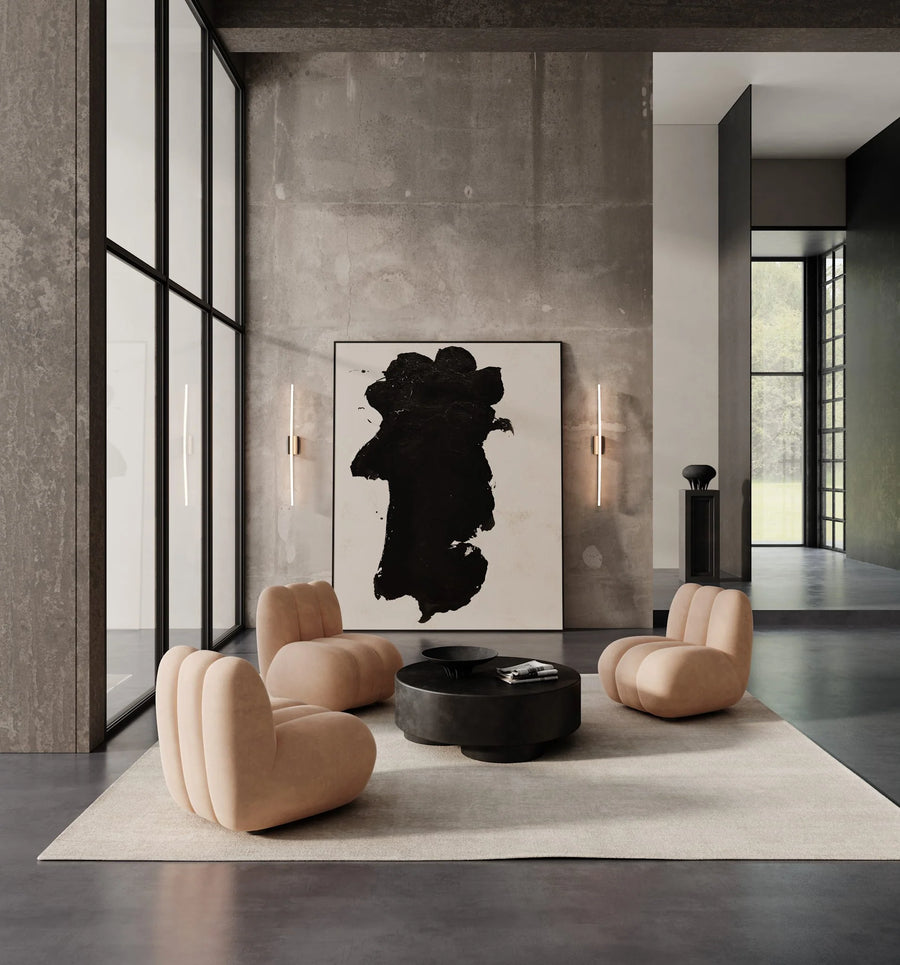 Modern living room with beige armchairs, a black coffee table, and abstract art on the wall.