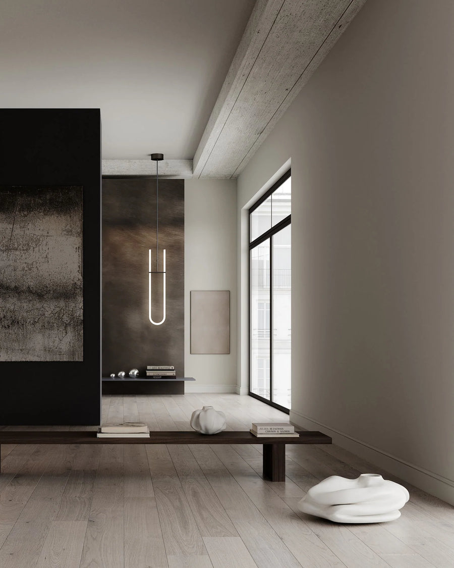 Modern interior with a long vertical light fixture, minimalist decor, and a large window.