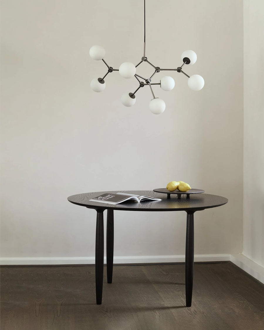 Modern dining table with a stylish pendant light in a minimalistic room.
