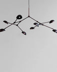 A modern design chandelier with 8 arms on a plain grey background from 101 Copenhagen available at Spacio retail stores in Mumbai & Kolkata. 