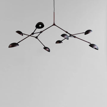 A modern design chandelier with 8 arms on a plain grey background from 101 Copenhagen available at Spacio retail stores in Mumbai & Kolkata. 