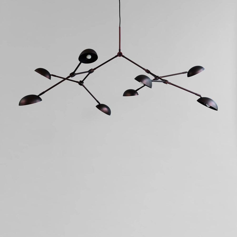 A modern design chandelier with 8 arms on a plain grey background from 101 Copenhagen available at Spacio retail stores in Mumbai & Kolkata. 