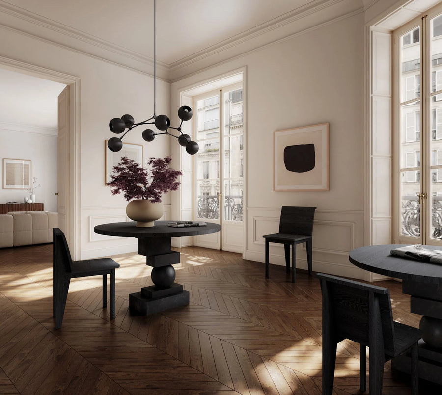 Modern interior with round black table and chairs in a well-lit room.