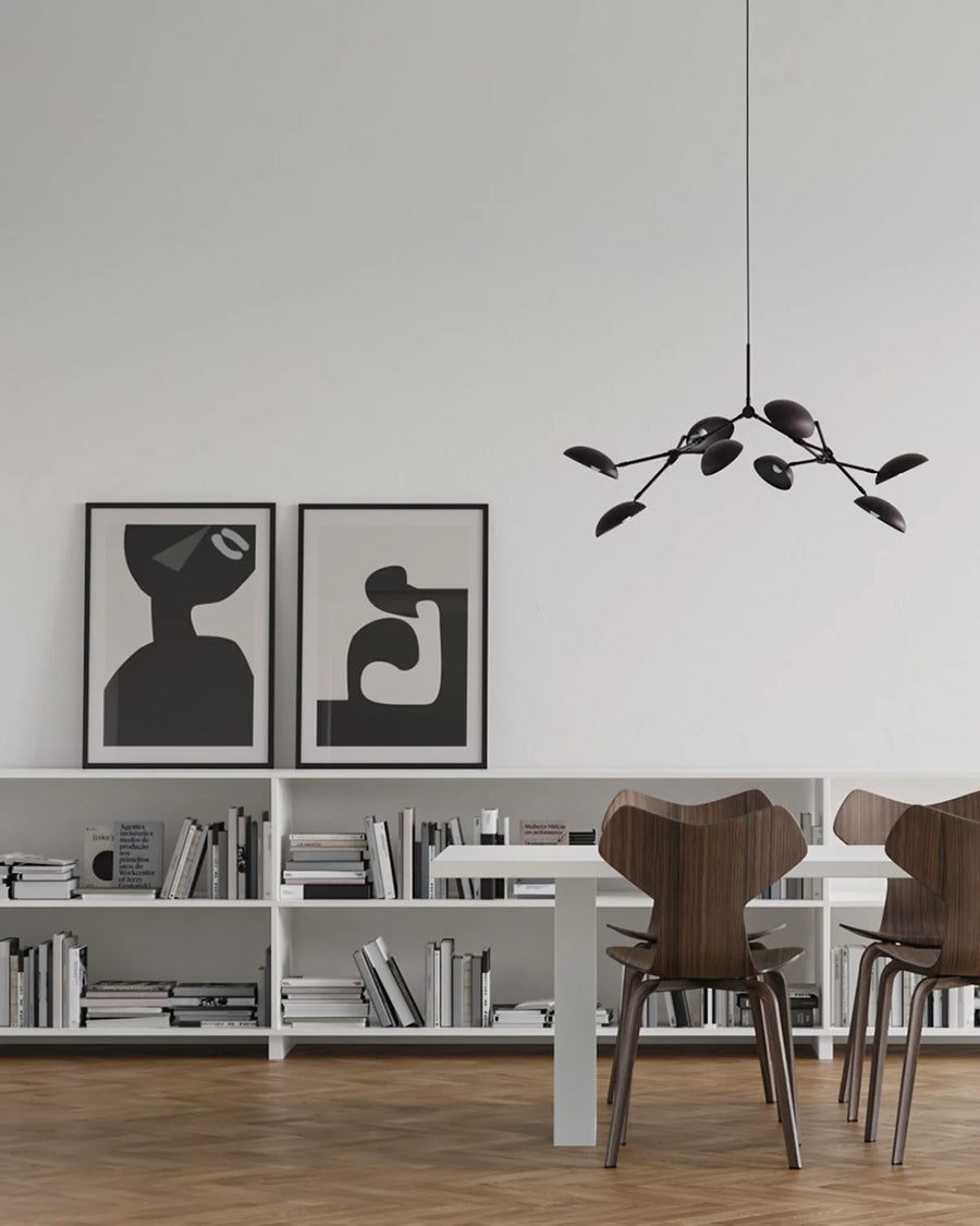 A Scandinavian theme dining room styled with books, wall art and a minimal design chandelier. 