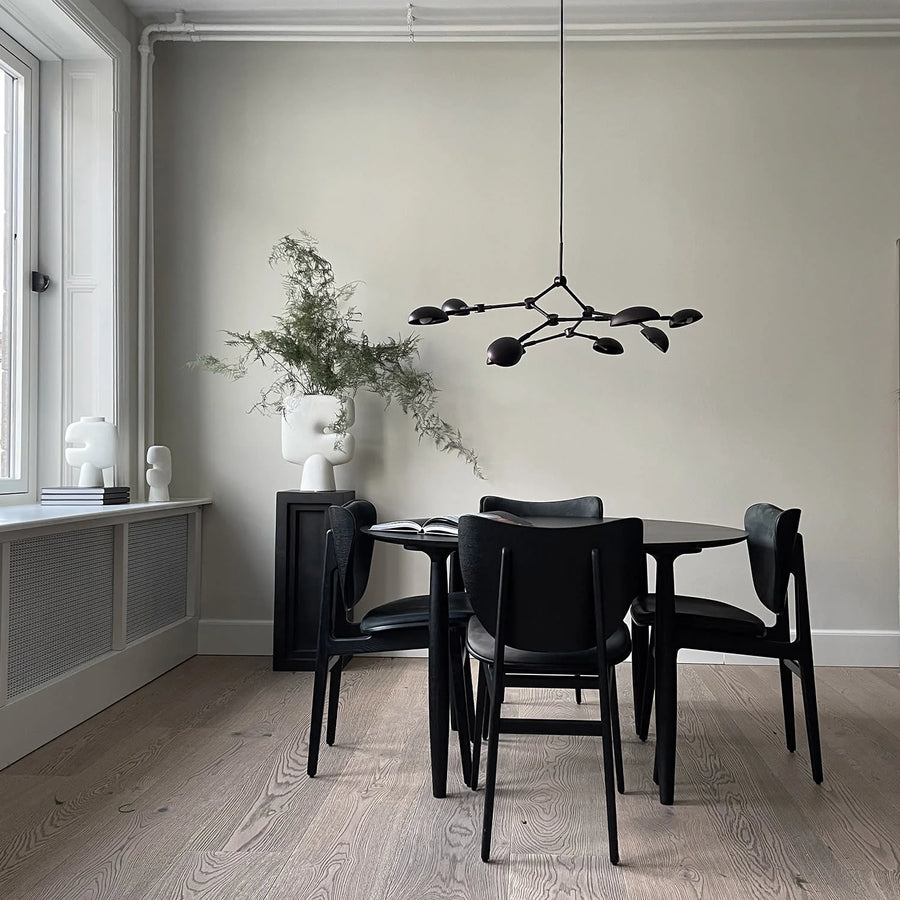 A Scandinavian theme dining room styled with sculptural vases , bowl and a minimal design chandelier. 