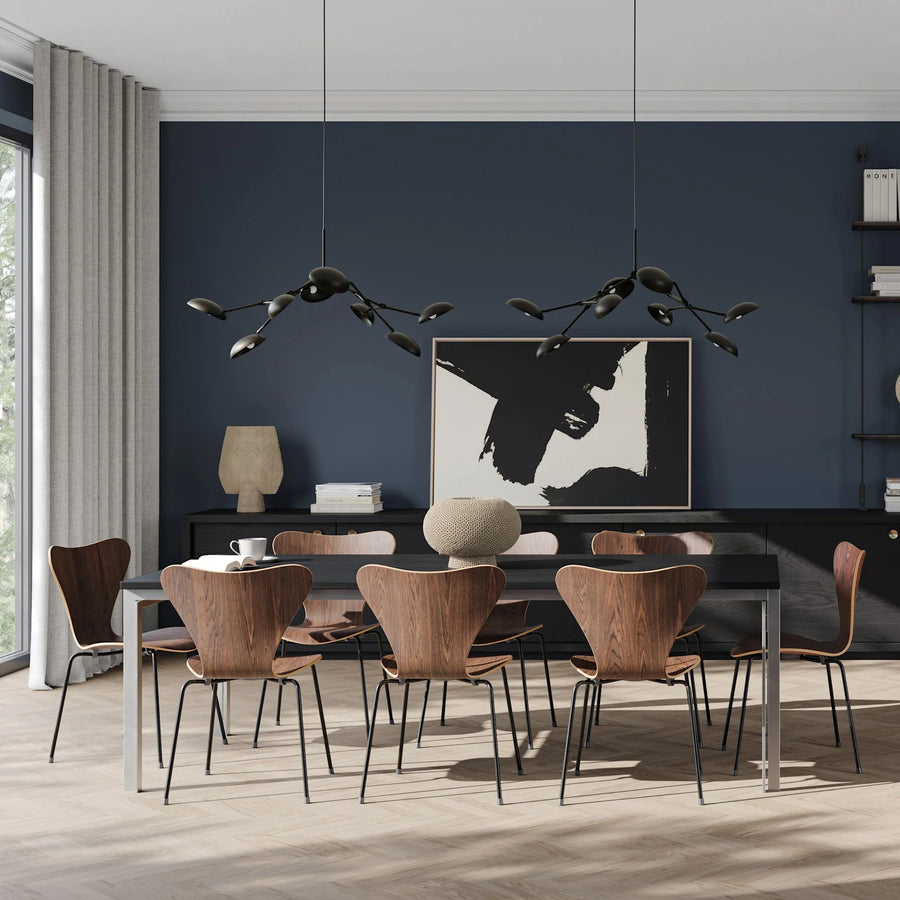 A modern theme dining room styled with 2 chandeliers, vases and wall art 