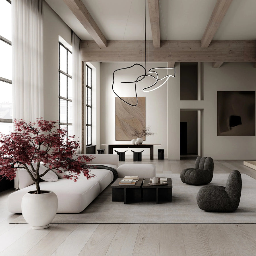 Modern living room with white sofa, gray chairs, and decorative plant.