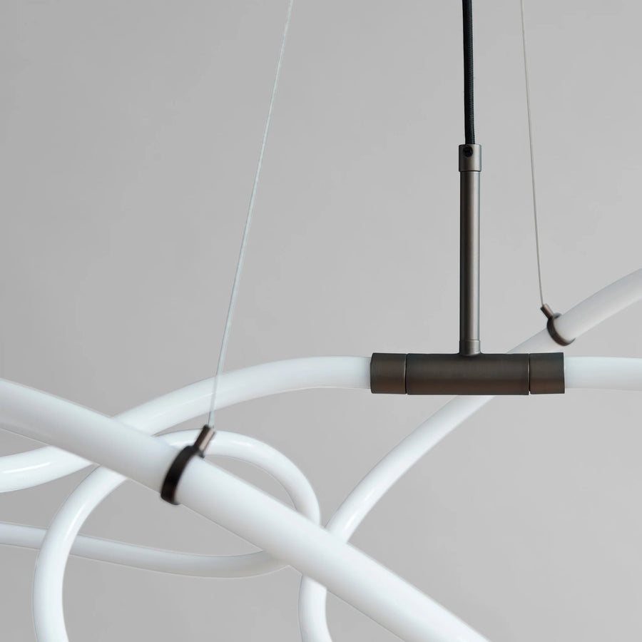 Modern chandelier with white arms and bronze fixture on a neutral background