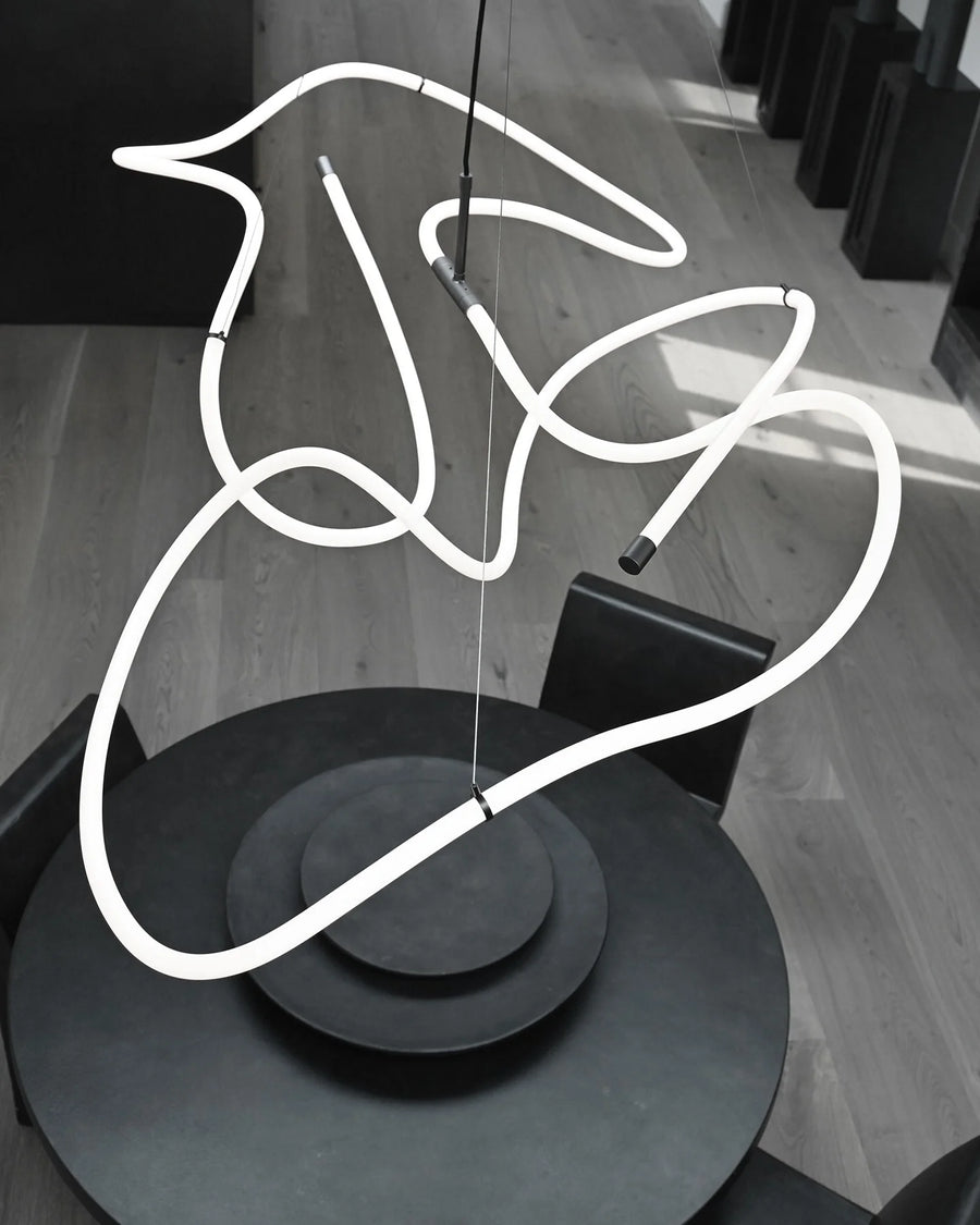 Neon light sculpture of a hand on a wooden floor
