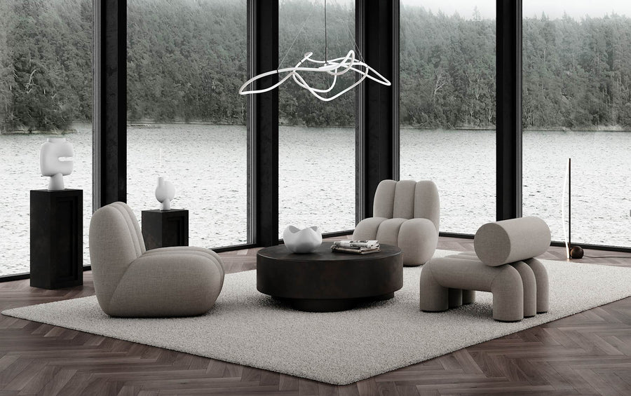 Modern living room with gray furniture and a large window view of water and trees.