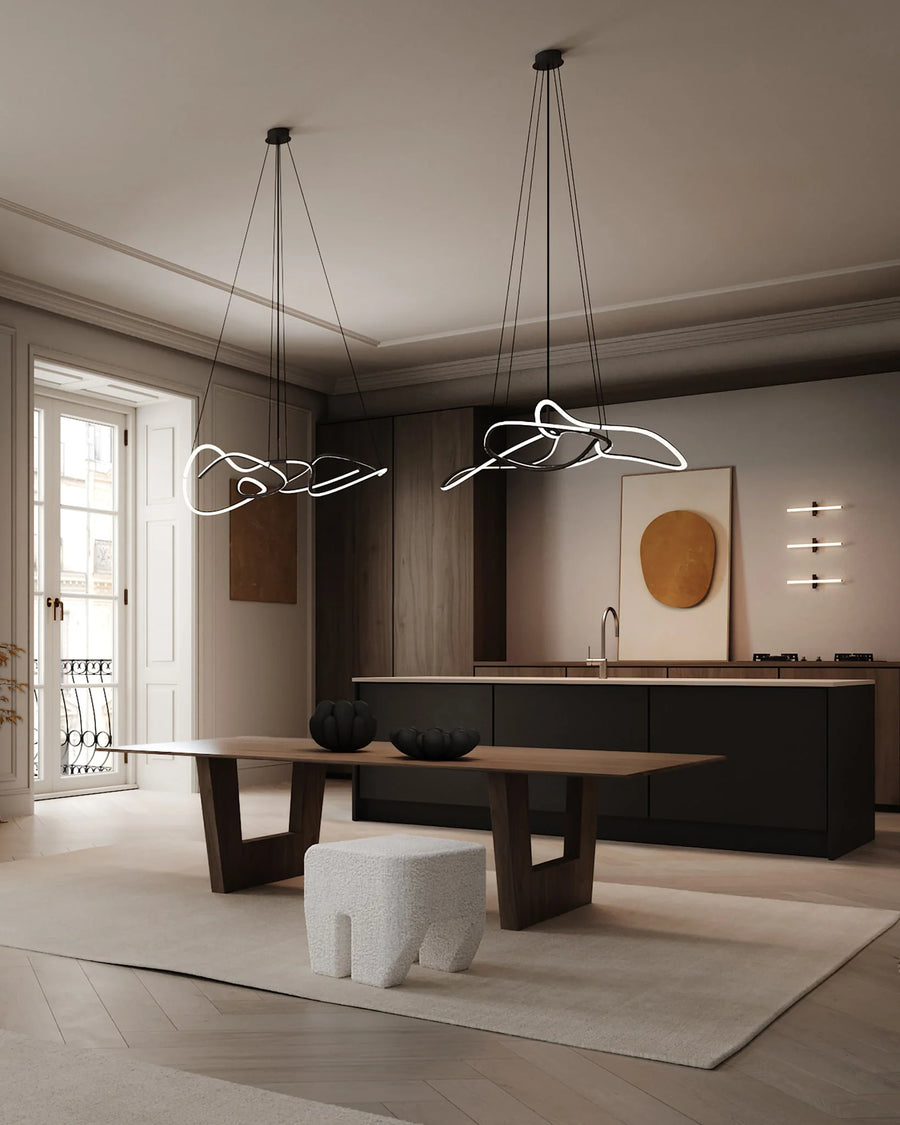 Modern kitchen with stylish chandeliers and a dining table.