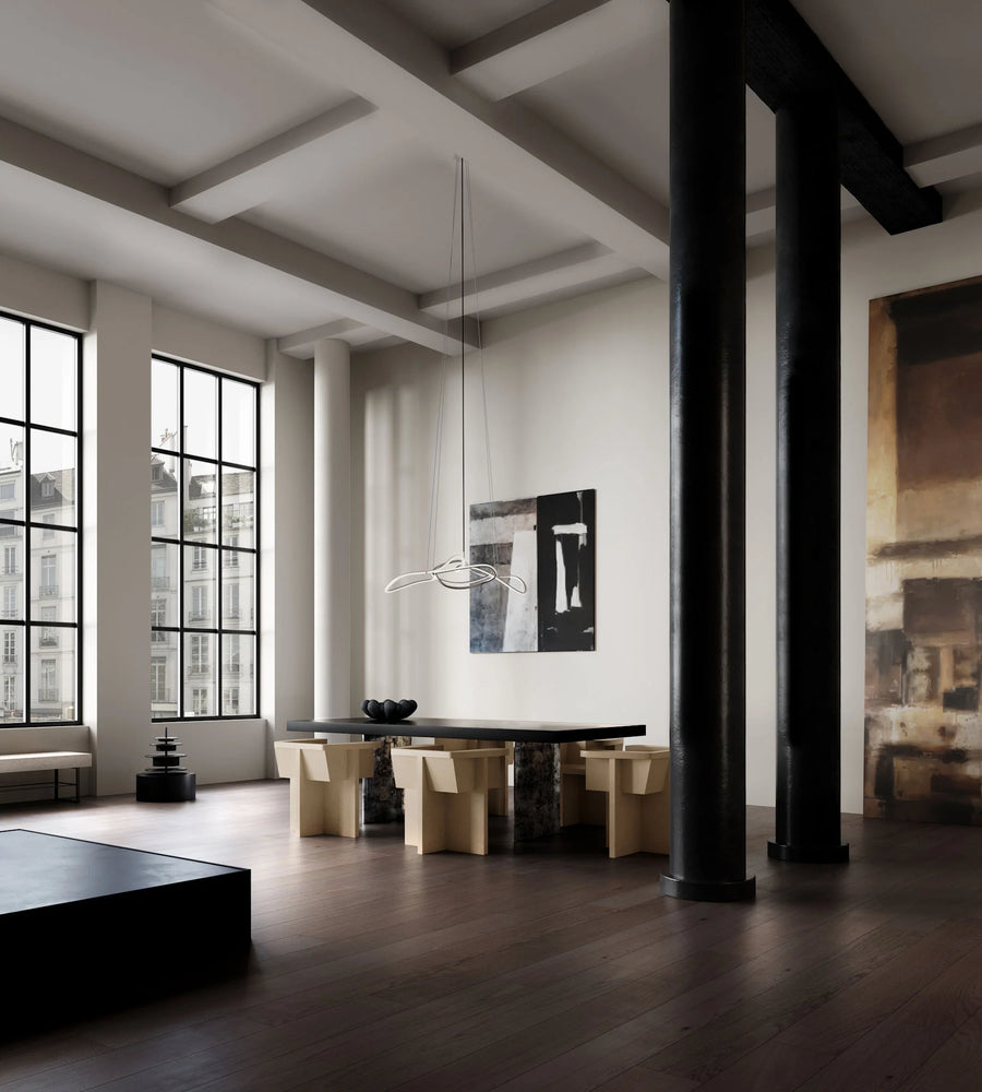 Modern interior with a dining table and chairs in a room with large windows and exposed beams.