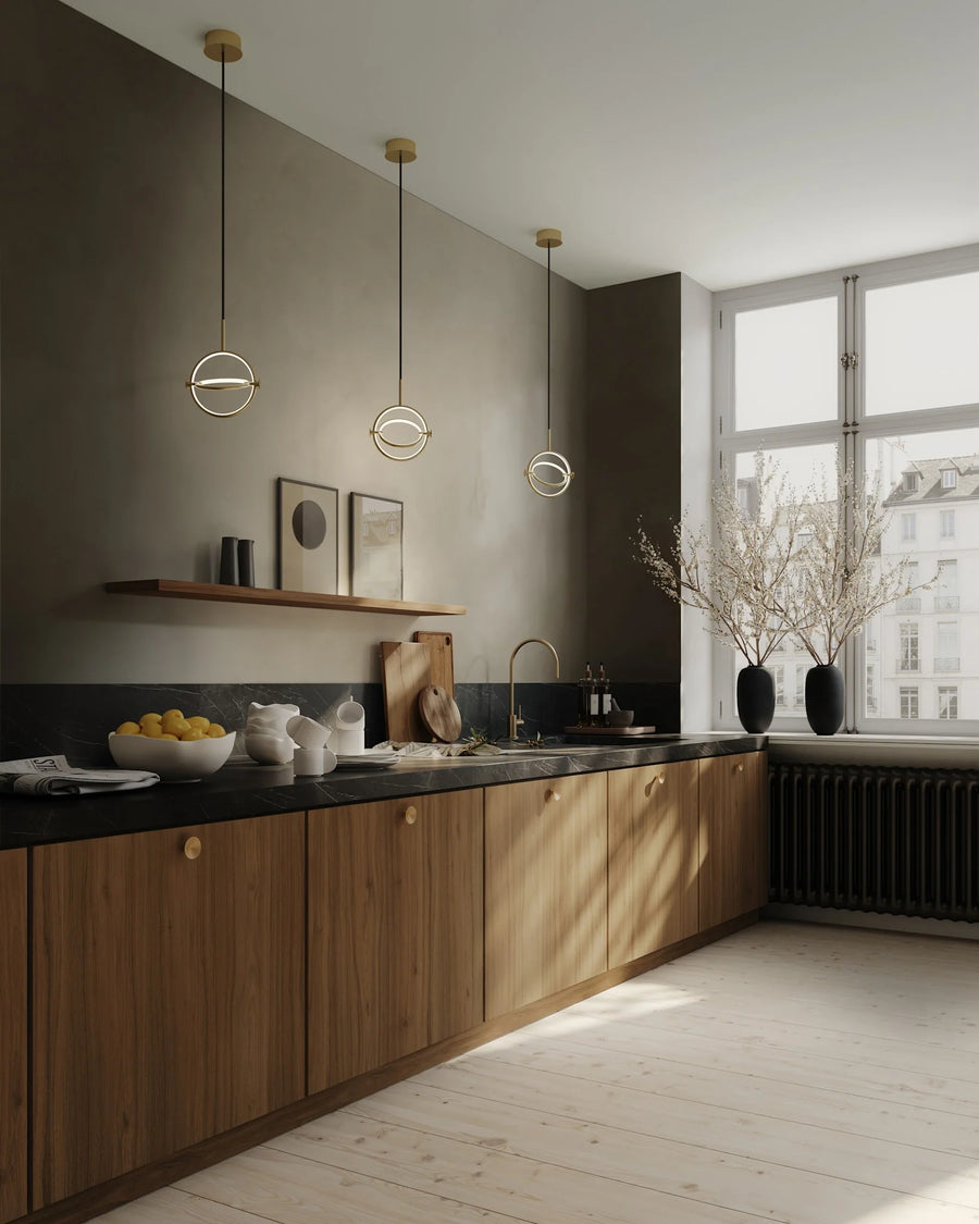 Modern Scandinavian theme kitchen with wooden cabinets, black countertops, and pendant lights.